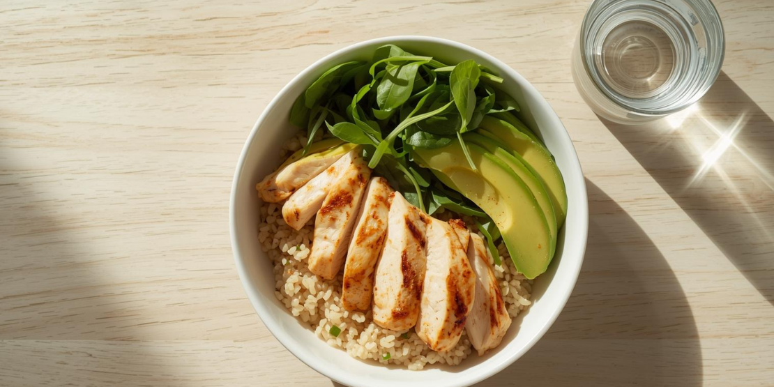 Primer idealnog obroka za oporavak posle HIIT treninga koji podržava reparaciju mišića i maksimalno iskorišćavanje Afterburn efekta. Zdrav, nutritivno bogat obrok serviran nakon treninga, koji sadrži grilovana pileća prsa, kinou i svežu salatu, simbolizujući pametan oporavak.